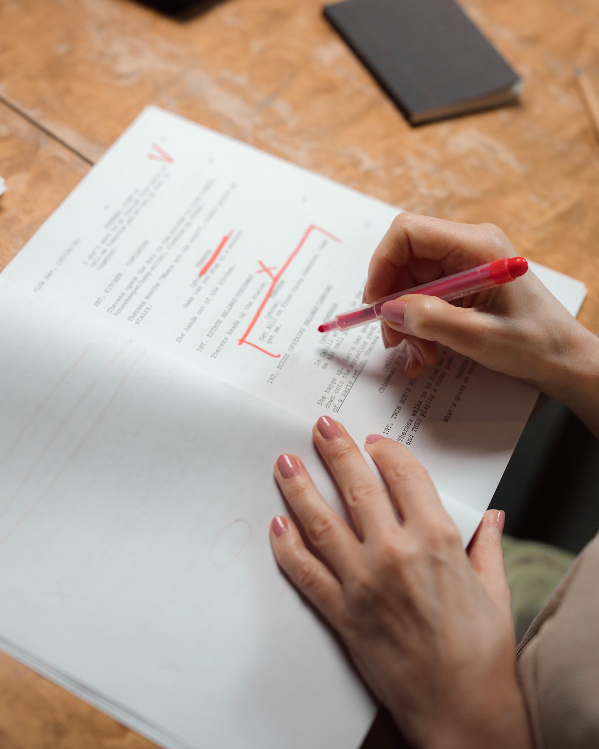 A consultant marks up a printed draft with a red pen