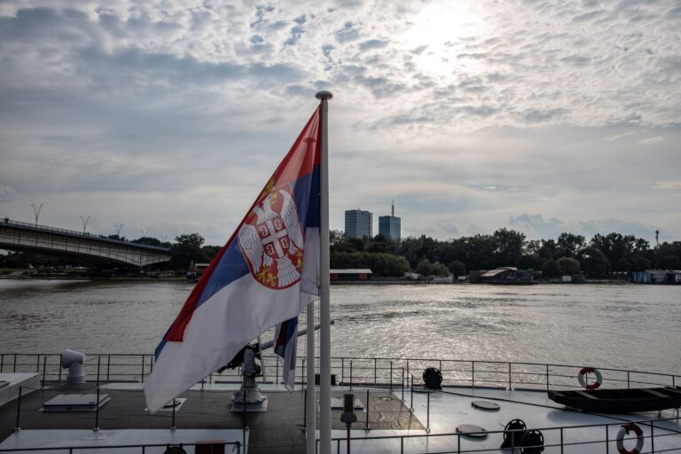 Флаг Сербии на фоне набережной Белграда — гражданство и паспорт Сербии