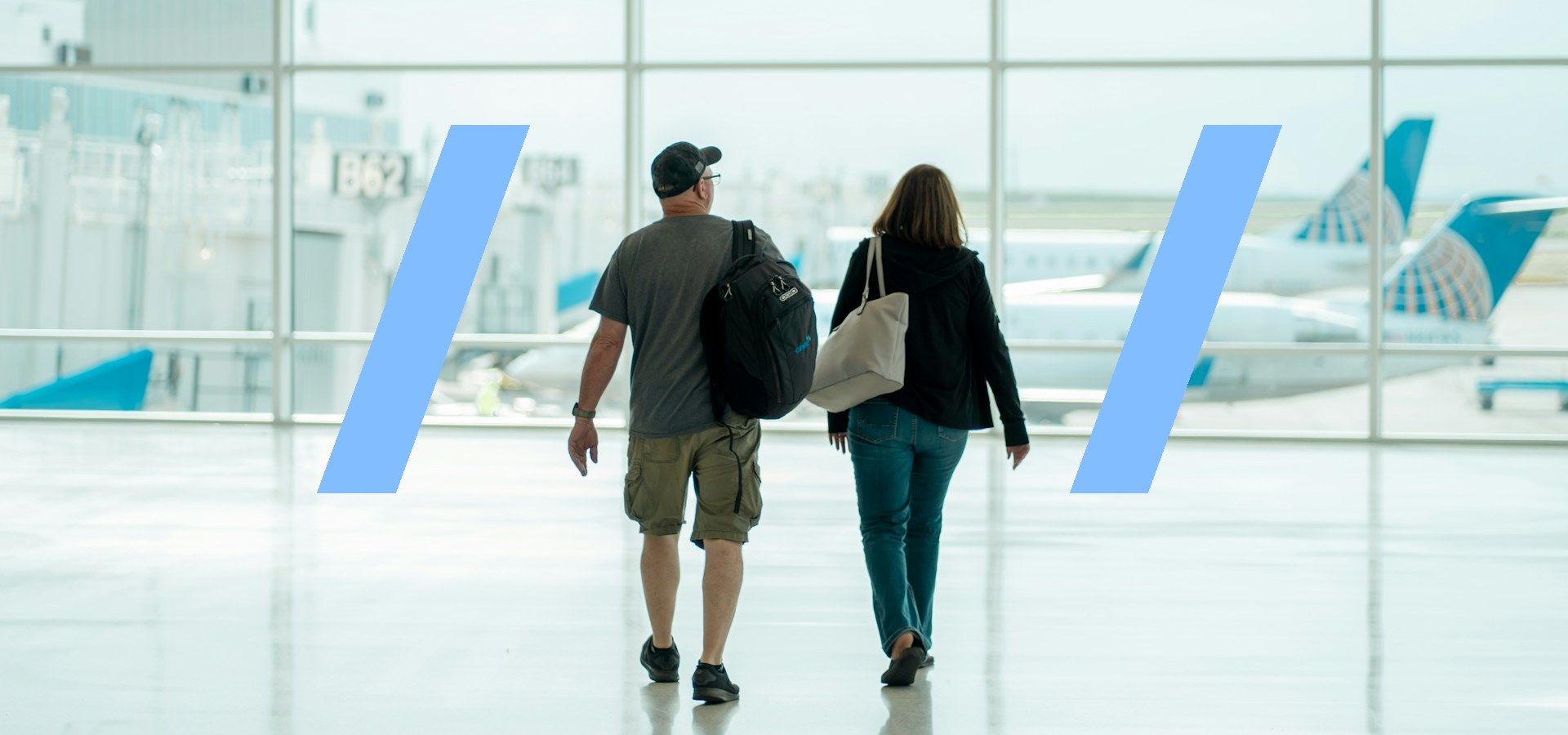 Two professionals with luggage walking through an airport terminal